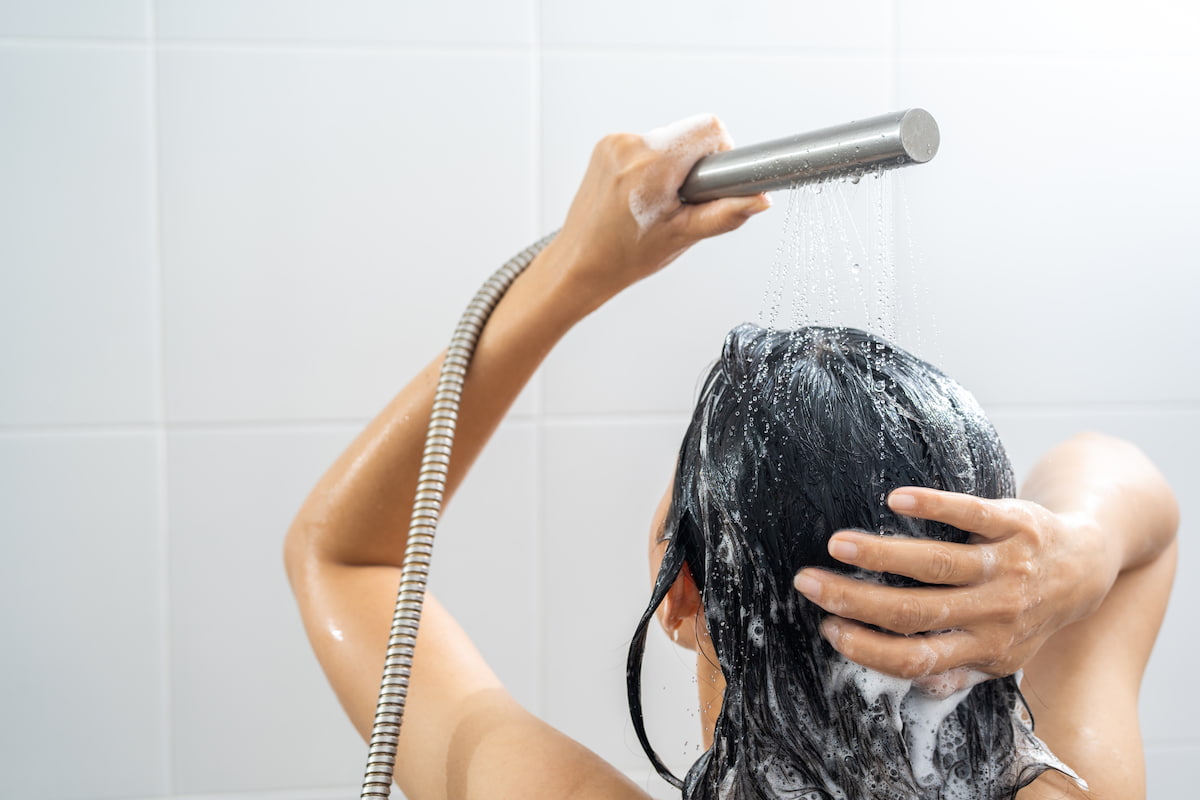 woman standing in the shower washing her hair