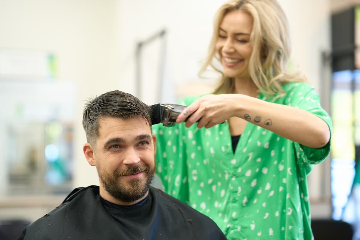 Great Clips stylist using clippers to give her customer a fade haircut