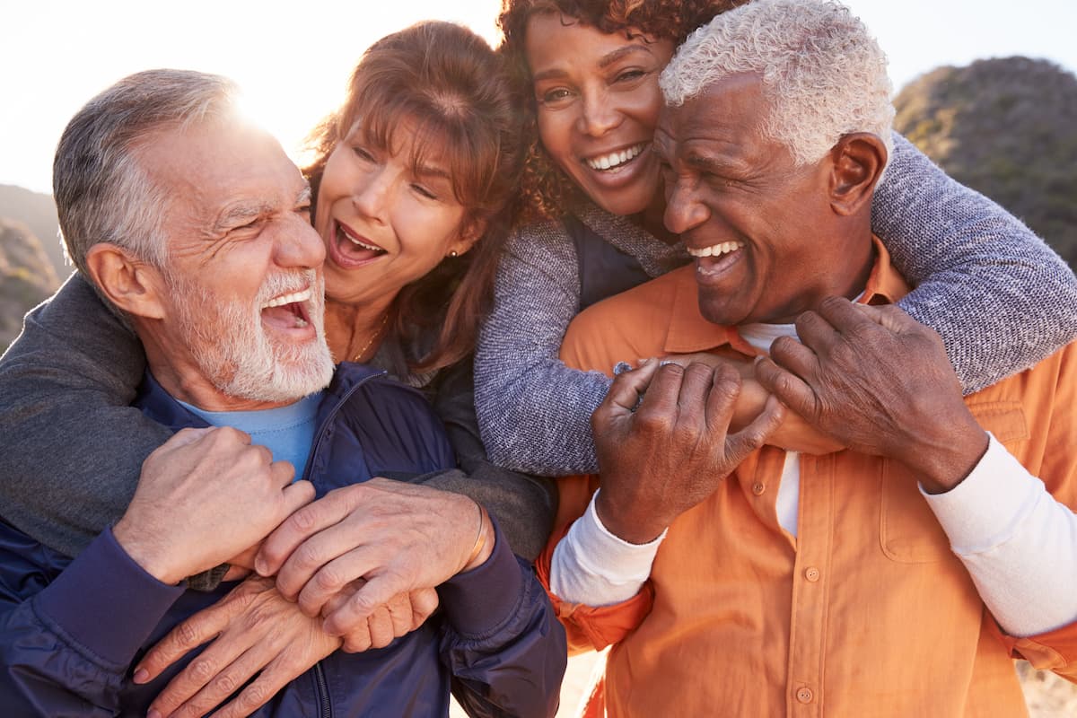 Two senior couples smiling and laughing together